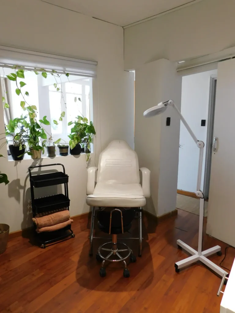 Sala de tratamientos en Sun Nails con silla reclinable, lámpara de aumento y decoración natural y relajante