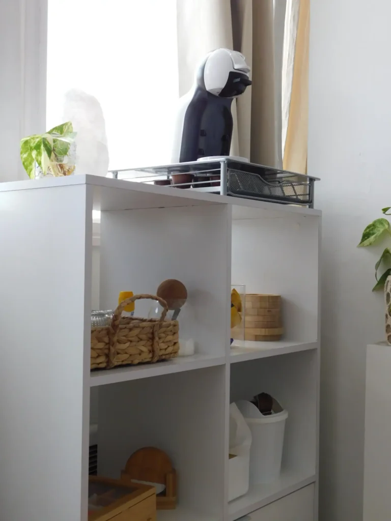 Estantería organizada en Sun Nails con cafetera, cesta y objetos de uso diario en un ambiente limpio y funcional